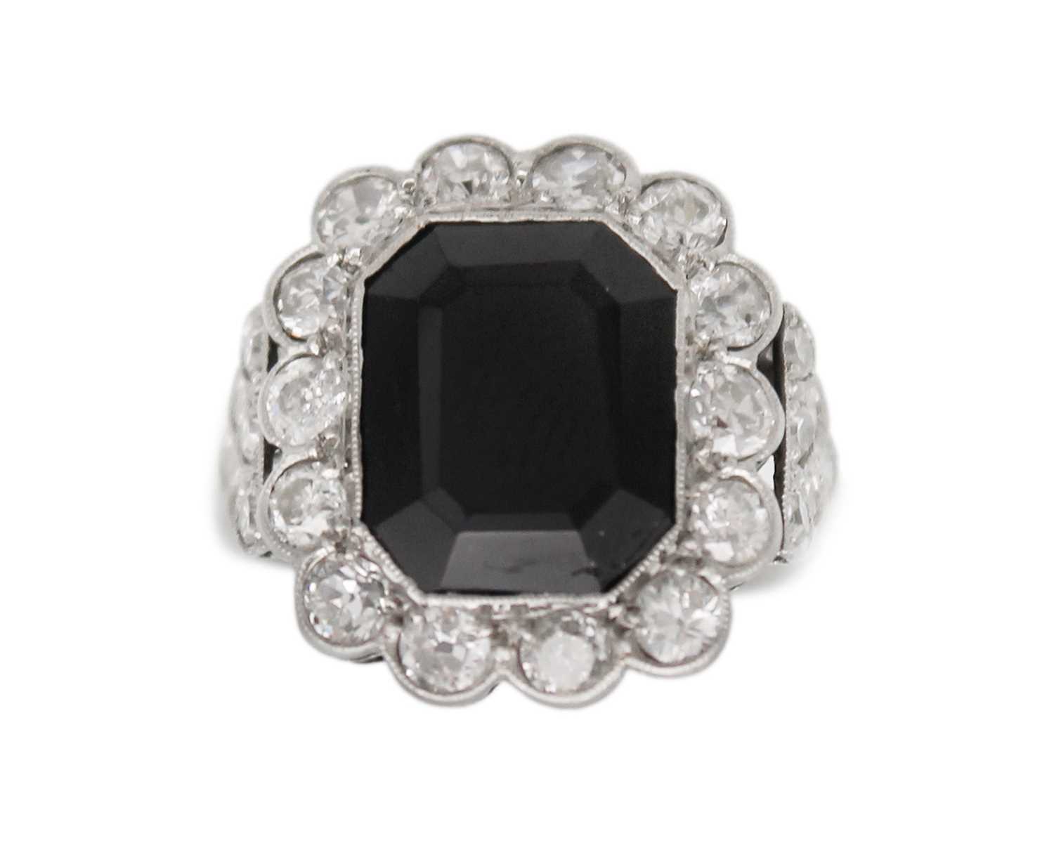 Lot 11 - An Art Deco style black onyx and diamond dress ring set in white gold.