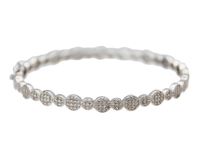 Lot 24 - A silver hinged bangle set with CZ clusters.