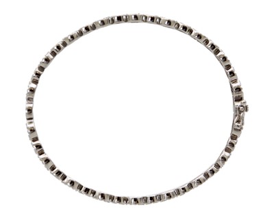 Lot 24 - A silver hinged bangle set with CZ clusters.