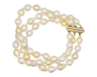 Lot 83 - A three-row golden and white South Sea cultured baroque pearl bracelet.