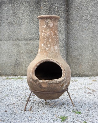Lot 774 - A terracotta chiminea on wrought iron stand.