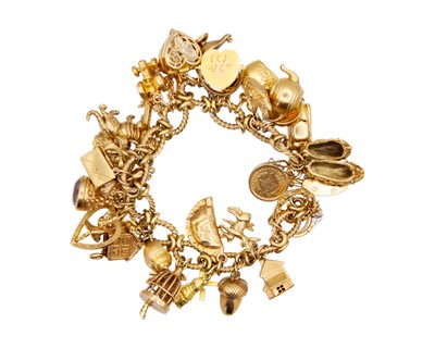 Lot 21 - A 9k charm bracelet applied with a good selection of 9k and gold charms.