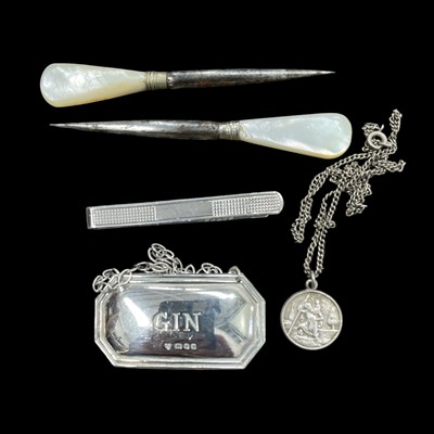 Lot 68 - A hallmarked silver "Gin" label, a tie clip,...