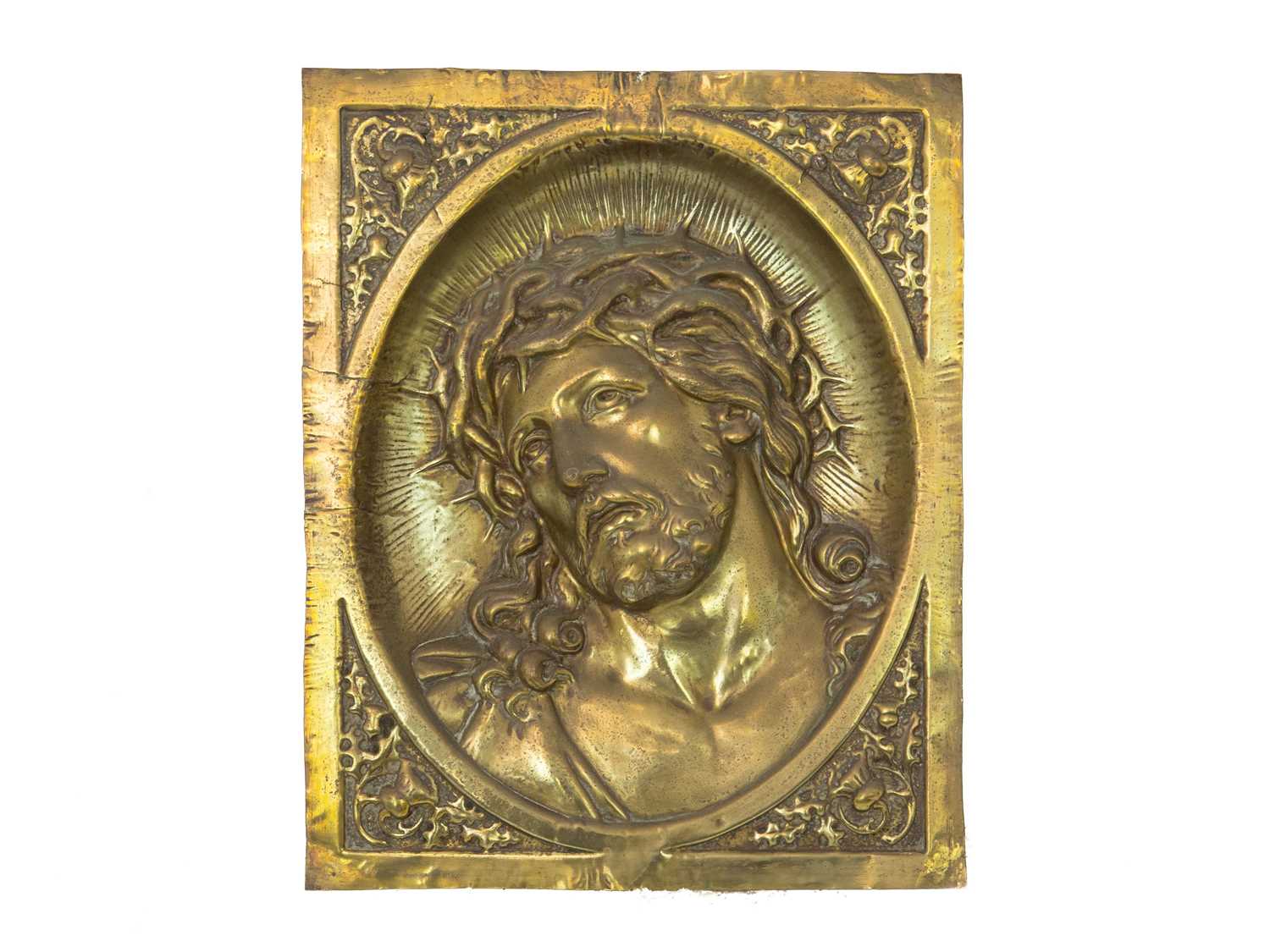 Lot 19 - A repoussé-decorated brass plaque, depicting the head of Christ.
