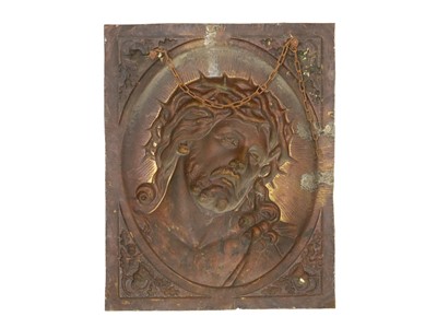 Lot 19 - A repoussé-decorated brass plaque, depicting the head of Christ.