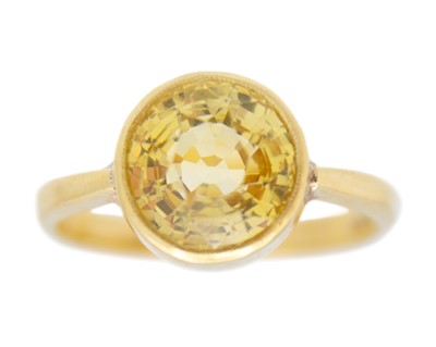 Lot 172 - A natural yellow sapphire set 18k gold solitaire ring.