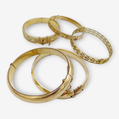 Lot 8 - A selection of five 9k and 12k rolled gold bangles.