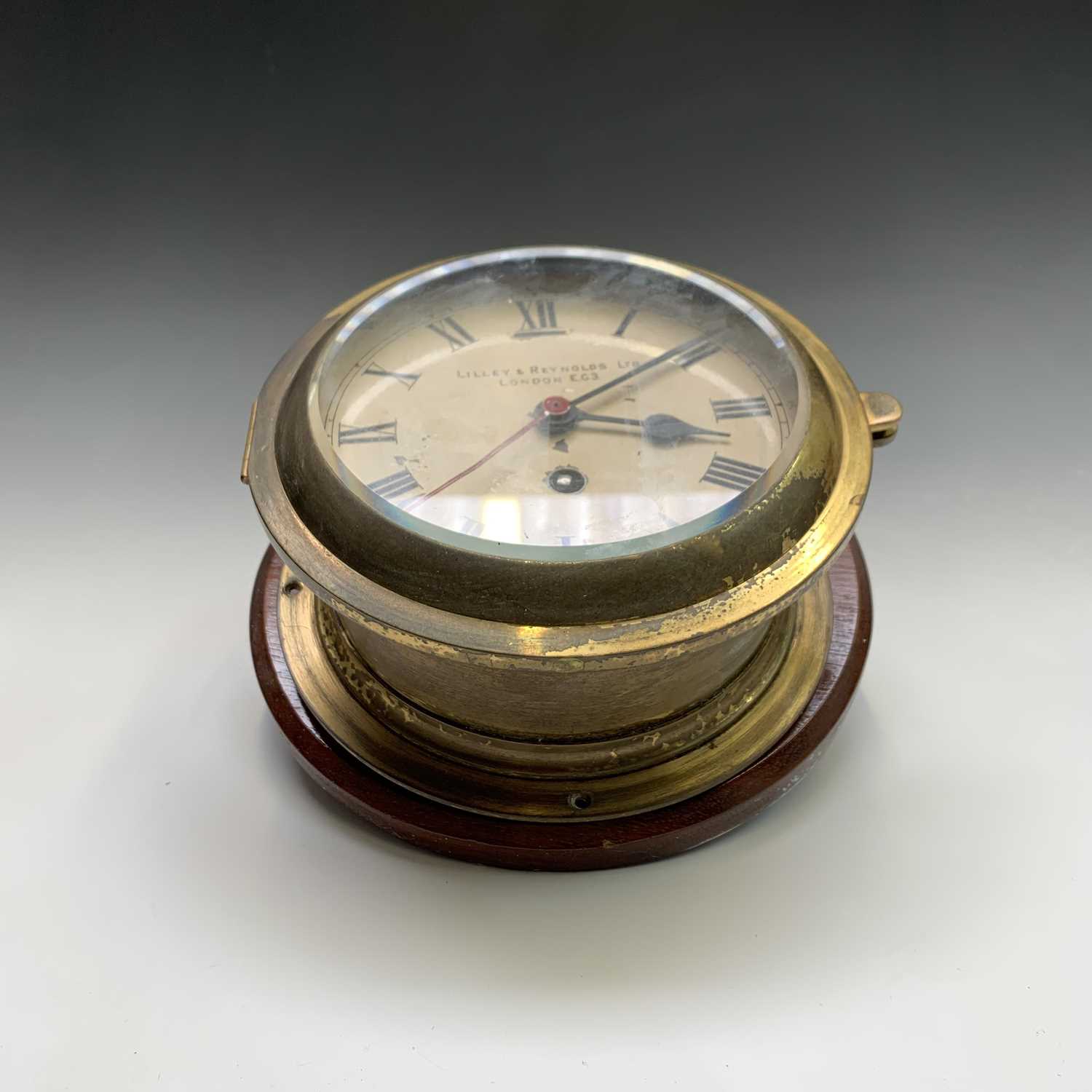 Lot 2908 - A ships brass bulkhead clock, the white