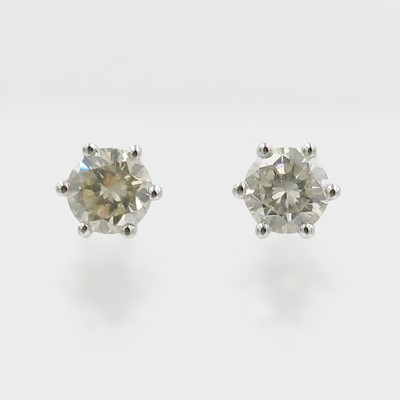 Lot 54 - A pair of 18k white gold diamond solitaire stud earrings.