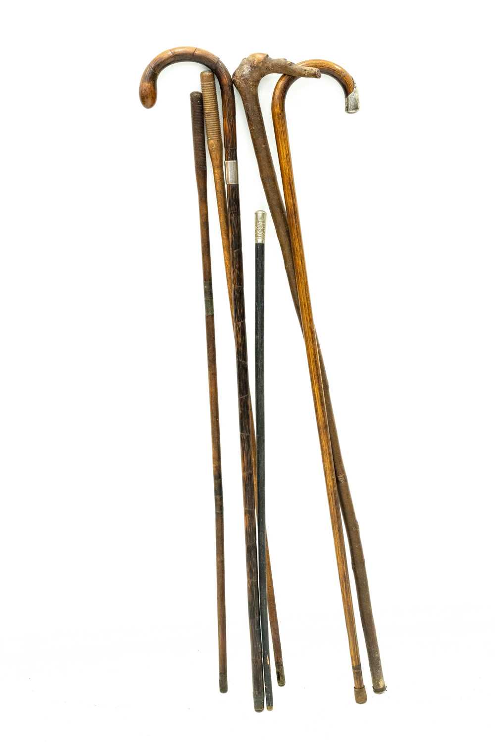 Lot 27 - Two silver mounted canes, another, a swagger stick, and two cleaning rods.