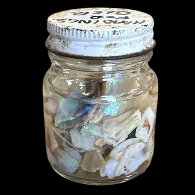Lot 177 - A small jar containing slices of opal in water.
