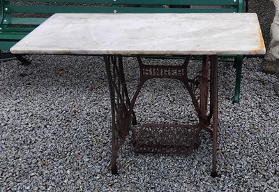 Lot 762 - A garden table. With rectangular marble top and cast iron Singer sewing machine base.