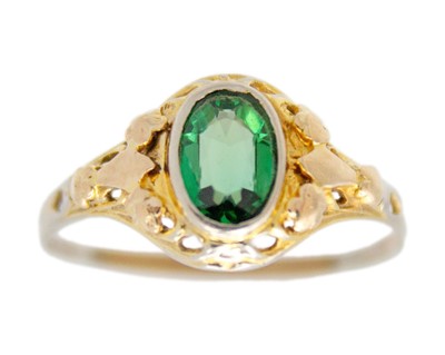 Lot 59 - A 10k bi-colour gold green paste set solitaire dress ring.