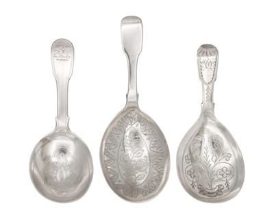 Lot 24 - A selection of three Georgian silver caddy spoons with bright cut decoration.