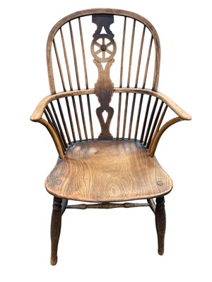 Lot 717 - An ash and elm wheelback Windsor elbow chair.