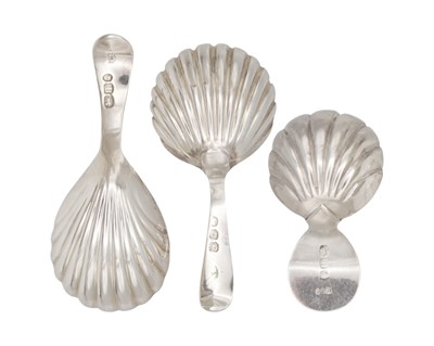 Lot 6 - A selection of three George III silver caddy spoons with scallop shell bowls and bright cut handles.
