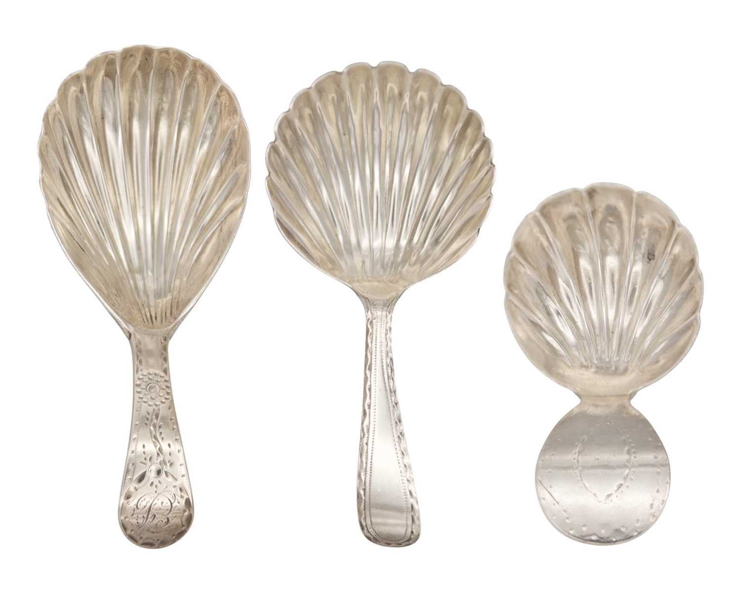 Lot 6 - A selection of three George III silver caddy spoons with scallop shell bowls and bright cut handles.