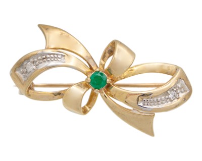 Lot 73 - A 9k gold emerald and diamond bow brooch.
