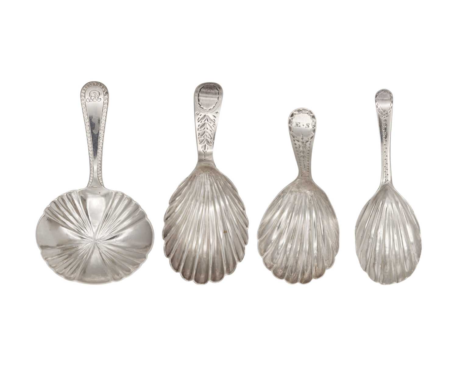 Lot 7 - A collection of four George III silver caddy spoons with scalloped bowls.