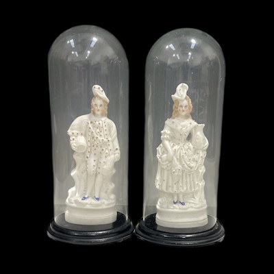 Lot 30 - A pair of porcelain figures under glass domes,...