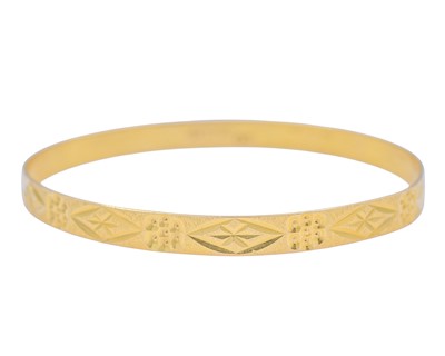 Lot 5 - A 21k gold engraved design bangle.