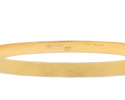 Lot 5 - A 21k gold engraved design bangle.