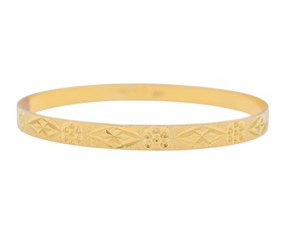 Lot 6 - A 21k gold engraved design bangle.