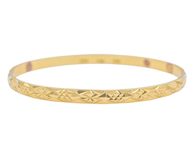 Lot 8 - A high-purity gold faceted bangle.