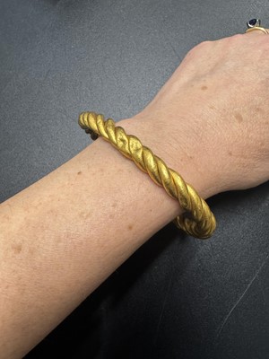 Lot 31 - A high-purity gold hollow twist bangle.