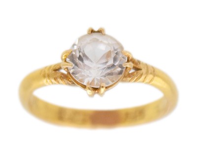 Lot 38 - A high-purity gold and white synthetic sapphire solitaire ring.