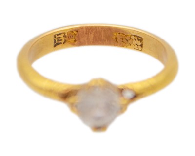 Lot 39 - A high-purity gold and white synthetic sapphire solitaire ring.