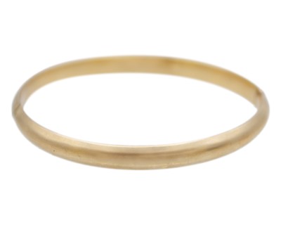 Lot 115 - A 14k gold hinged bangle.