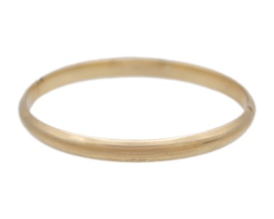 Lot 114 - A 14k gold hinged bangle.