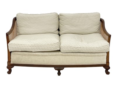 Lot 929 - A 1920s walnut bergere cane two seater settee.