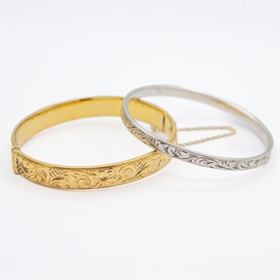 Lot 11 - One silver bangle and one 9k gold metal cored bangle.