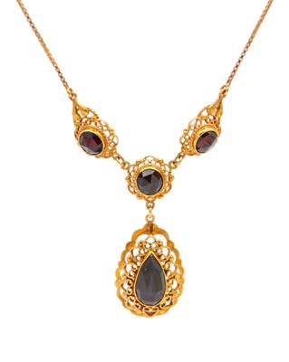Lot 23 - A 14k rose gold and garnet pendant necklace with a pair of matched earrings.