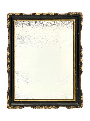 Lot 507 - A carved wood, ebonised, and gilt rectangular wall mirror.
