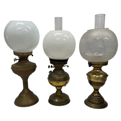 Lot 198 - Three brass oil lamps. Two are converted to...
