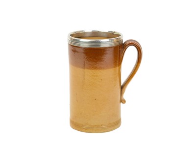 Lot 799 - A large Victorian brown salt glazed mug, with a silver mounted rim.