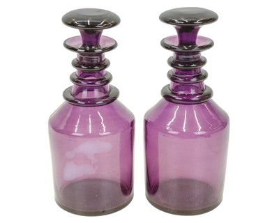 Lot 351 - A pair of triple ring neck amethyst glass decanters and stoppers.