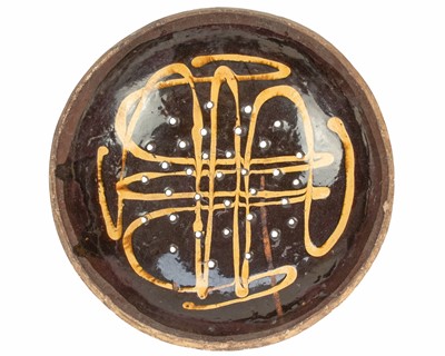 Lot 622 - An English slipware pottery colander or strainer dish.