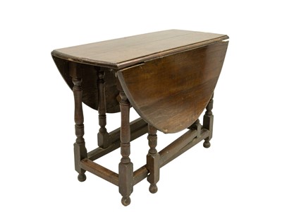 Lot 909 - An oak oval gateleg dining table.