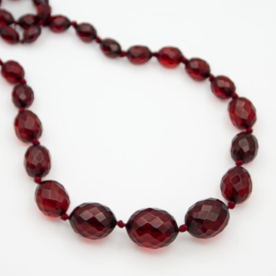 Lot 21 - A faceted cherry amber-style graduated bead necklace.
