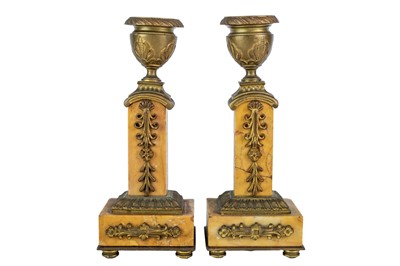 Lot 22 - A pair of orange siena marble candlesticks.