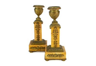 Lot 22 - A pair of orange siena marble candlesticks.