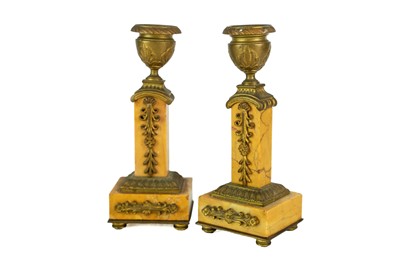 Lot 22 - A pair of orange siena marble candlesticks.