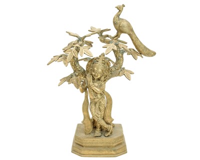 Lot 399 - A brass figure group of Krishna under a tree.
