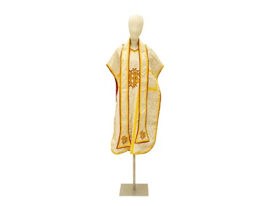 Lot 555 - Liturgical Vestments - a white brocade chasuble with gold border and red lining.