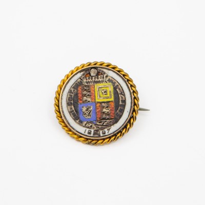 Lot A 1887 Queen Victoria Jubilee silver sixpence in a yellow metal frame.