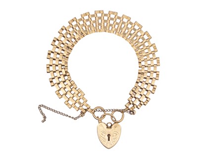 Lot 214 - A 9k gold seven-row gate link bracelet with a padlock clasp.